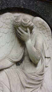 A statue of an angel with hands covering eyes.