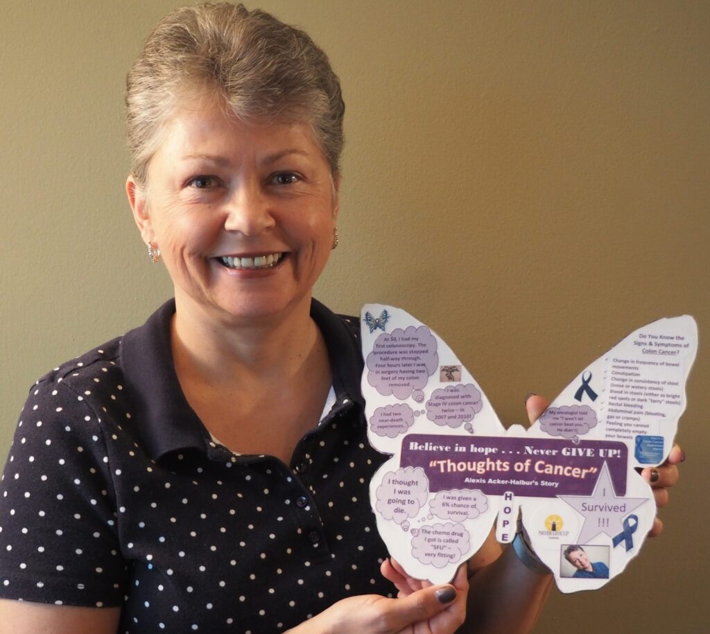 A woman holding up a butterfly shaped flyer.