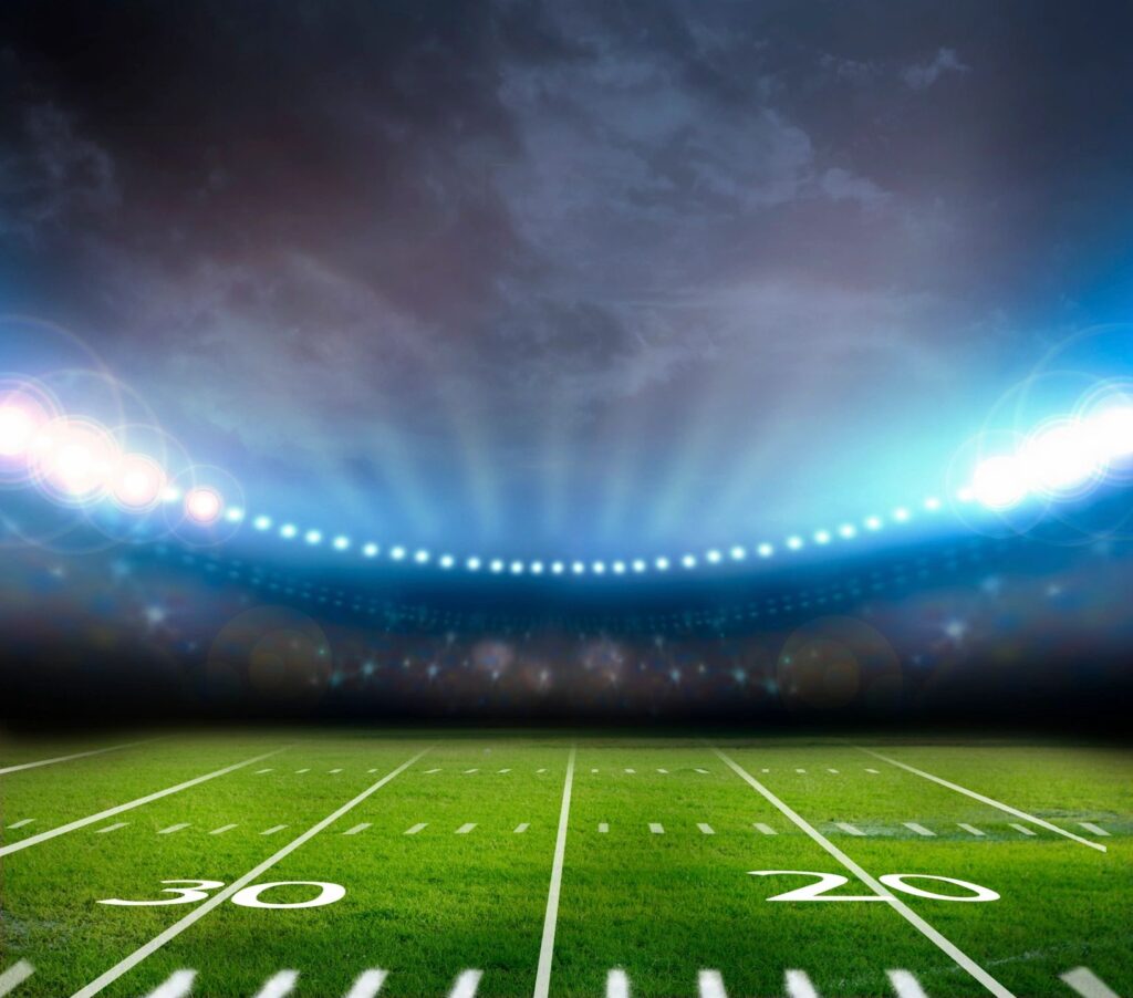 A football field with lights on the side of it.